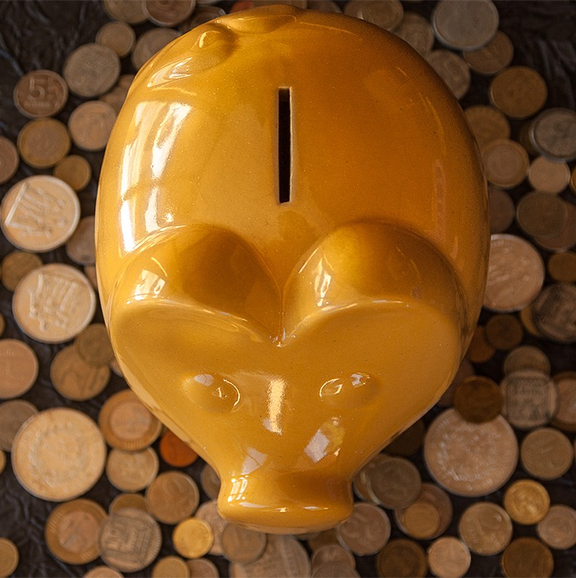 a gold piggy bank surrounded by coins