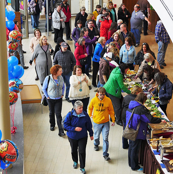 a crowd of UW staff walking around display tables during staff recognition day festivities