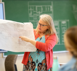 Teacher with interior design blueprints