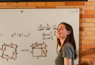 CASM tutor stands in front of math diagrams on whiteboard