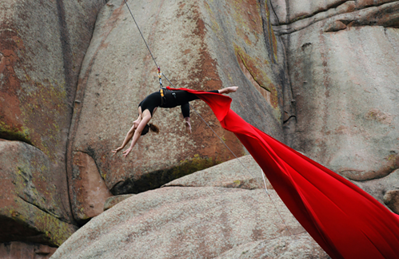 a photo of a vertical dancer performing on the rock formations at Vedauwoo