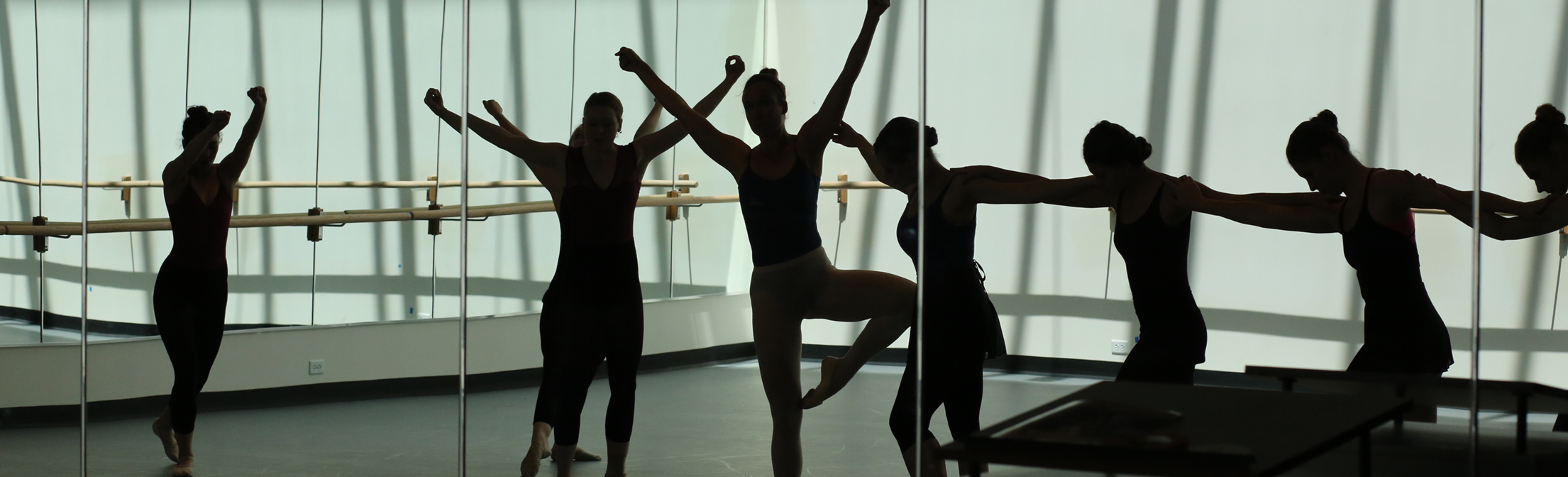 Photo of silhouetted dancers in the studio