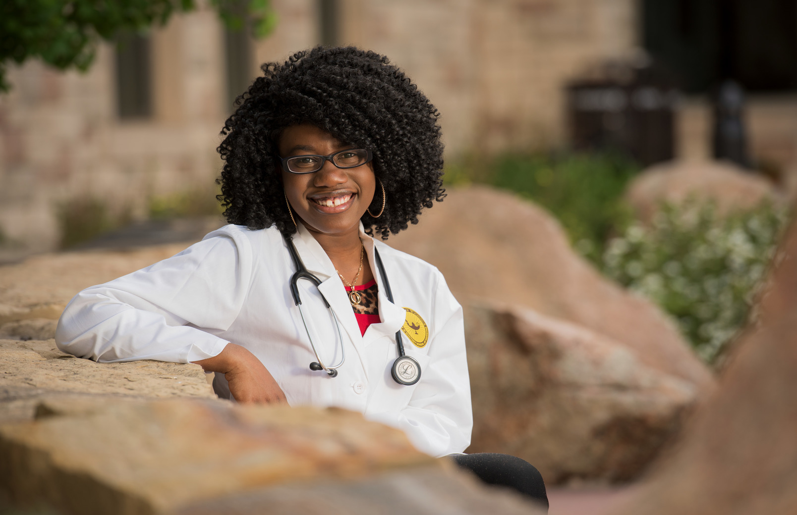A student poses outside in their nursing jacket on campus.