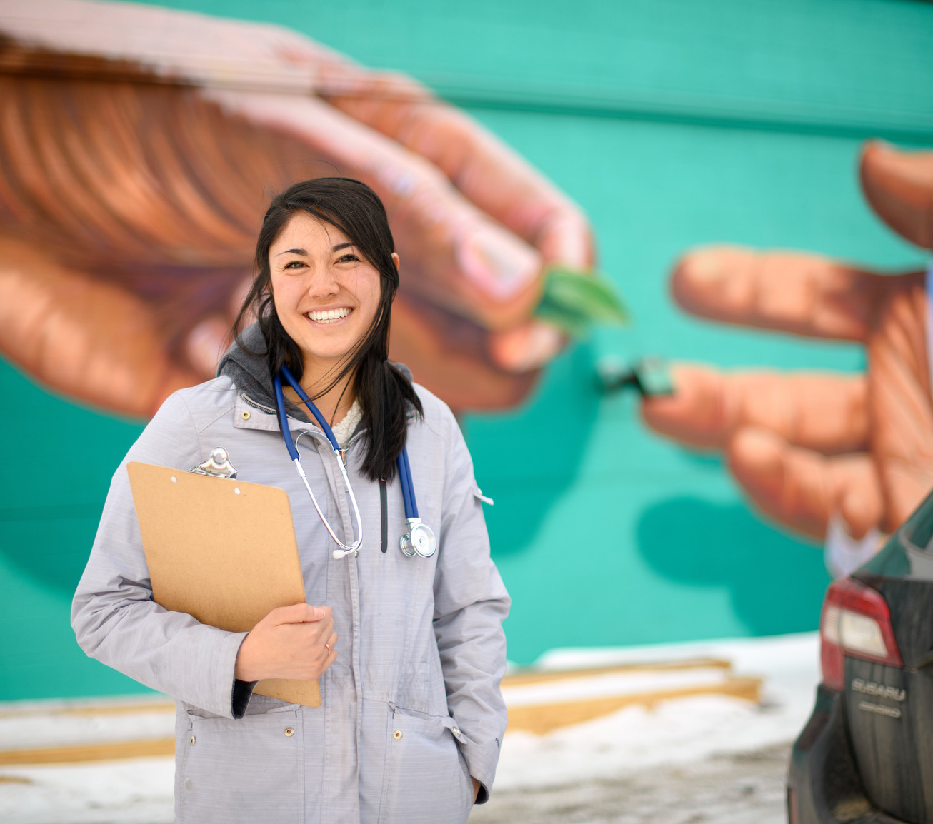 Nurse standing in front of mural