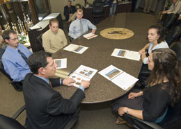 Six people sitting around conference table