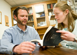 Professor and student looking at book