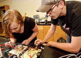 Two students working on circuit board