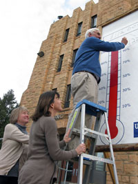Three people adjusting fundraiser tally