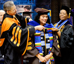 Three people at graduation ceremony