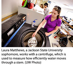 Laura Matthews, a Jackson State University sophomore, works with a centrifuge, which is used to measure how efficiently water moves through a stem. 