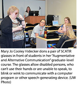 Mary Jo Cooley Hidecker dons a pair of SCATIR glasses in front of students in her “Augmentative and Alternative Communication” graduate-level course. The glasses allow disabled persons, who can’t use their hands or are unable to speak, to blink or wink to communicate with a computer program or other speech-generating device.