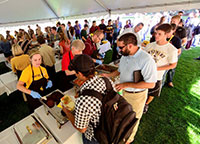 people lining up for food inside a tent