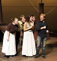 two men and two women following a man on a stage set