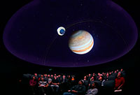 people in planetarium looking up at display