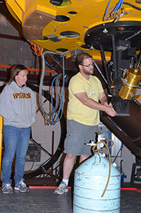 woman and man working beneath a telescope at observatory