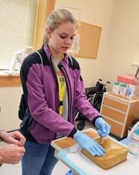 young woman practicing injection in simulated skin block
