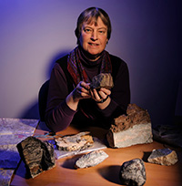 woman sitting at table and holding rocks