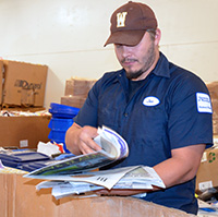 man sorting paper into a box