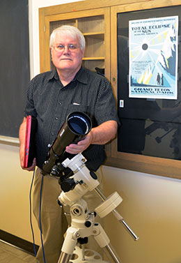 man in hallway with telescope