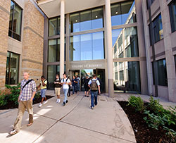 students walking in and out of a large buildling