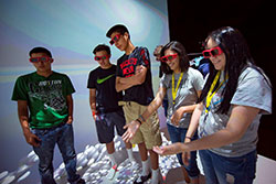 three boys and two girls wearing three D glasses in a special room