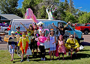 group of adults and children in homemade costumes outside in front of a van