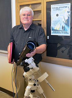 man holding a telescope