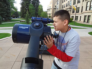 young man looking through a small telescope