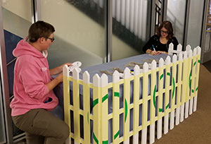 two people with a picket fence display