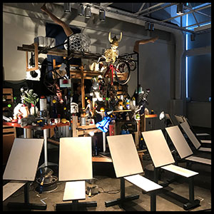 easels and drawing boards set up around display of many objects