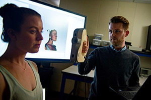 man scanning woman's head with hand-held scanner