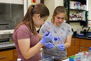 two teenage girls doing a science experiment
