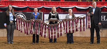 holding a line of ribbons and a trophy