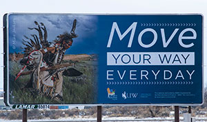 billboard with a picture of a Native American doing a traditional dance