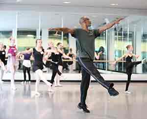 man leading a group of dancers in a dance studio