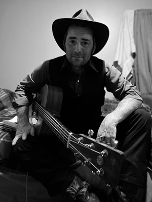 black and white photo of a man with a guitar