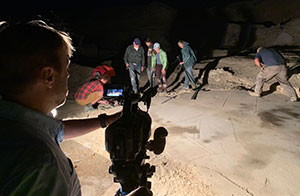 people working in a quarry at night under bright lights