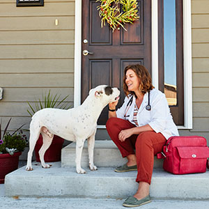 woman and dog on steps in front of house