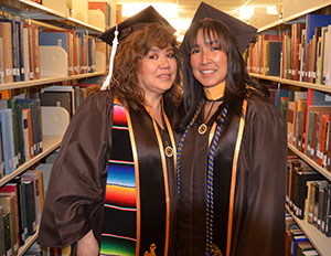 two women in caps and gowns standing together