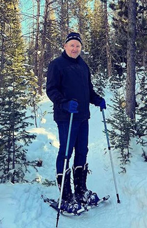 man on snowshoes in snowy forest
