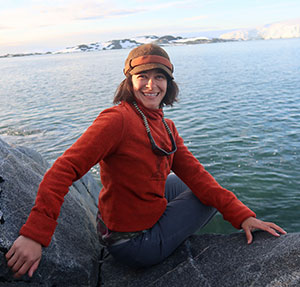 woman sitting on rocks by lake