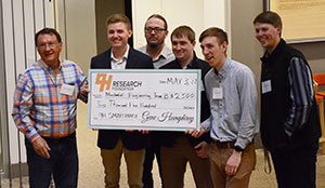 group of people holding up an oversized check