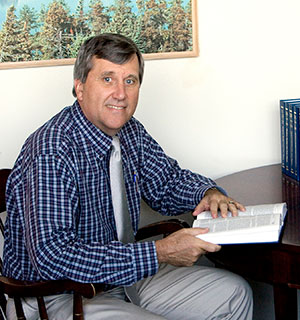 man sitting at a desk with an open book