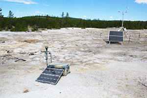 scientific equipment in sandy area with mountains in background
