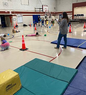 people in a gym filled with equipment and mats