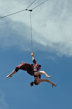 dancer held upside down with harness and wires