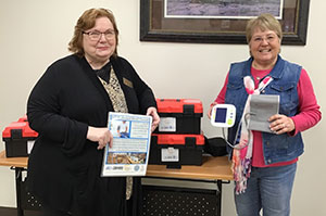 two women displaying blood pressure check kits