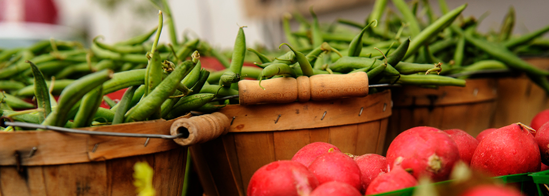 baskets of beans with radishes in foreground