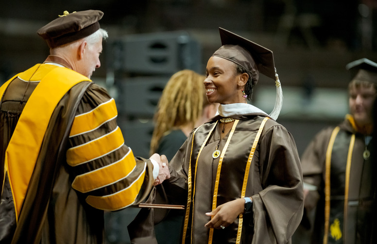 graduate shaking hands with the UW president at commencement 