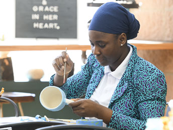 woman painting a mug